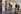 A gallery space with people wandering around in it, looking at the art works and text. 