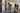 A gallery space with people wandering around in it, looking at the art works and text. 